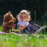 Little girl telling her cuddly toy a story.