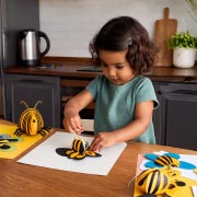 Young girl making bee crafts.